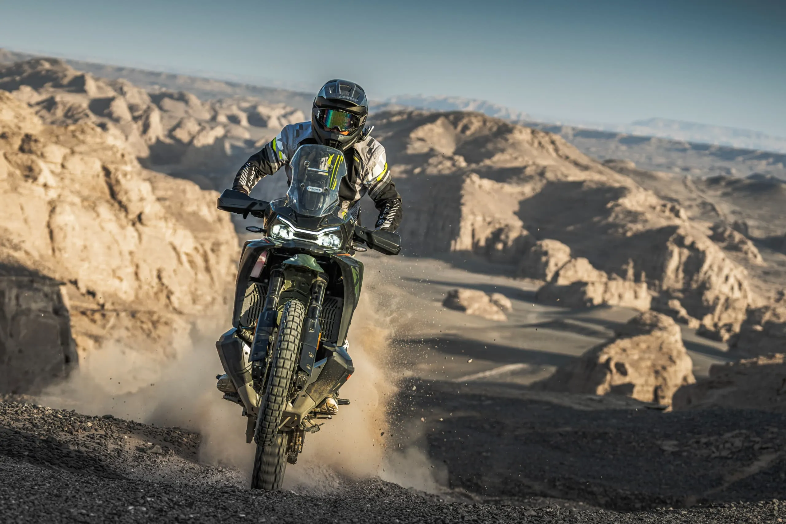 CFMoto 1000MT-X en action sur une piste de terre, dans un décor de canyon