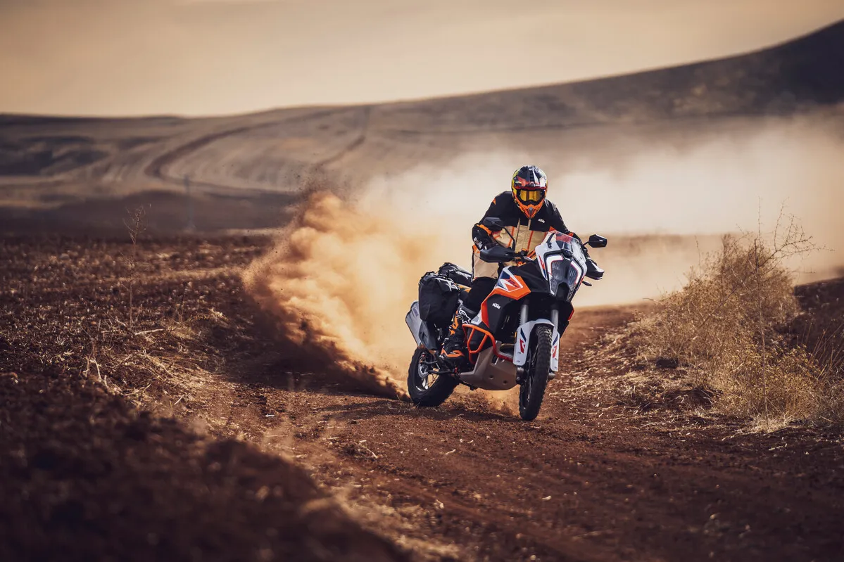 KTM 1290 Super Adventure R soulevant un nuage de poussière sur une piste