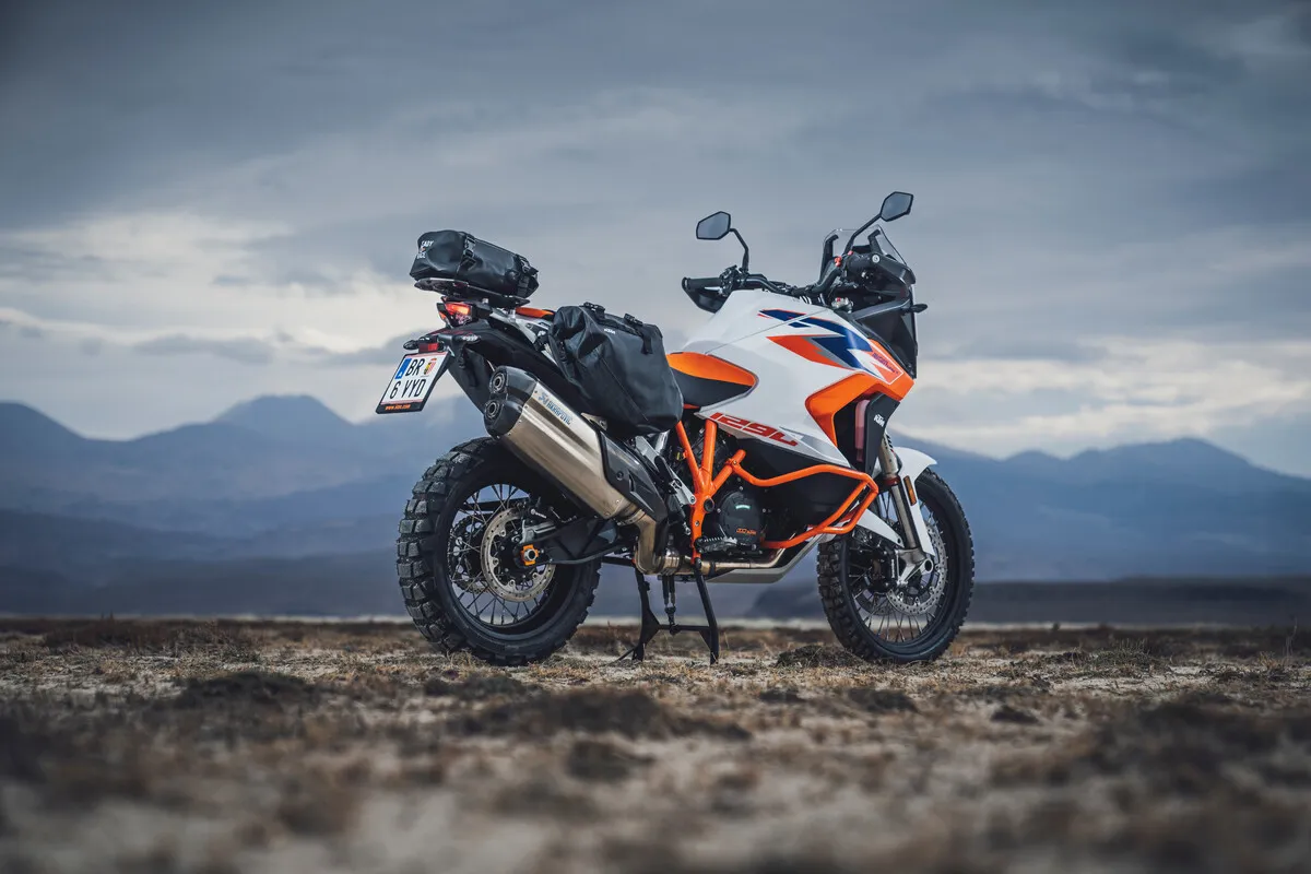 KTM 1290 Super Adventure R équipée d'un top-case, à l'arrêt dans un paysage désertique