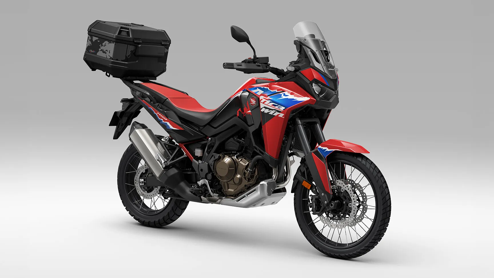 Honda CRF1100L Africa Twin en studio, équipée d'un top-case, vue de trois-quarts arrière